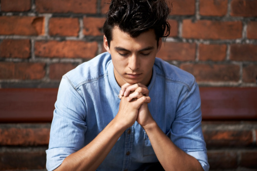 Looking for reassurance A young man praying for the answers
